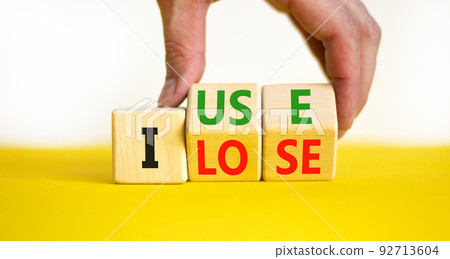 I use or lose it symbol. Concept words I use and I lose on wooden cubes. Businessman hand. Beautiful yellow table white background. Business and i use or lose it concept. Copy space. 92713604
