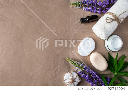 Natural organic cosmetics and lupine flowers on craft paper background. Moisturizing cream, soap and towel. Natural organic cosmetics and lupine flowers on craft paper background. Moisturizing cream, soap and towel. 92714004