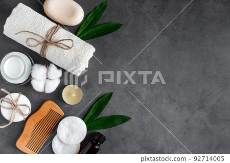 Natural body care cosmetics on concrete background. Spa accessories, towel, hairbrush, essential oil. 92714005