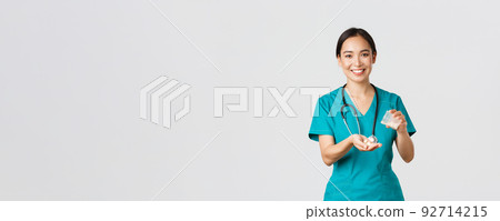Healthcare workers, preventing virus, quarantine campaign concept. Smiling friendly asian female doctor, physician in scrubs, give patient medication from container, white background Healthcare workers, preventing virus, quarantine campaign concept. Smiling friendly asian female doctor, physician in scrubs, give patient medication from container, white background 92714215