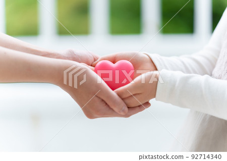 Parent and child hands holding a heart 92714340
