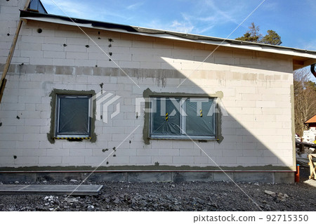 Facade of white block building under construction works. Facade of white block building under construction works. 92715350