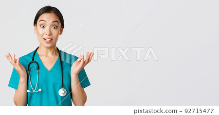 Healthcare workers, preventing virus, quarantine campaign concept. Close-up of surprised and amused, happy asian female nurse, physician hear great news, raise hands amazed and look camera 92715477