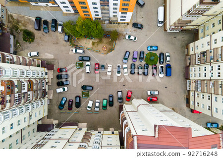Aerial view of parked cars on parking lot between high apartment buildings. 92716248