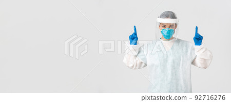 Covid-19, coronavirus disease, healthcare workers concept. Serious-looking young asian female doctor, tech lab employee in respirator and personal protective equipment, white background Covid-19, coronavirus disease, healthcare workers concept. Serious-looking young asian female doctor, tech lab employee in respirator and personal protective equipment, white background 92716276