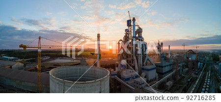 Aerial view of cement factory tower with high concrete plant structure at industrial production area. Manufacturing and global industry concept. Aerial view of cement factory tower with high concrete plant structure at industrial production area. Manufacturing and global industry concept. 92716285
