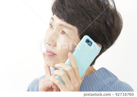 高級女性在打電話時思考她的智能手機白色背景 92716760