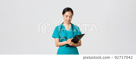 Healthcare workers, preventing virus, quarantine campaign concept. Serious-looking professional female doctor, nurse in scrubs writing down info on clipboard, examine patient, white background Healthcare workers, preventing virus, quarantine campaign concept. Serious-looking professional female doctor, nurse in scrubs writing down info on clipboard, examine patient, white background 92717042