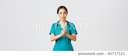 Covid-19, healthcare workers, pandemic concept. Hopeful serious-looking asian nurse, doctor asking something with concerned face, clench hands together in support during coronavirus, white background 92717121