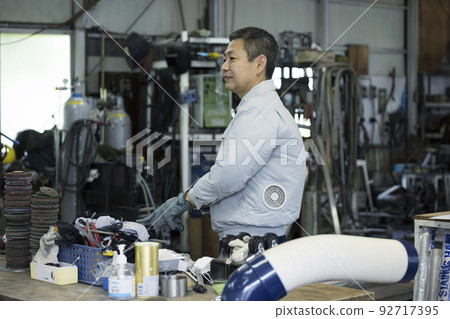 Male worker preparing with welding gloves in the factory Male worker preparing with welding gloves in the factory 92717395