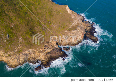 Ocean waves splash against rock on island Ocean waves splash against rock on island 92717866