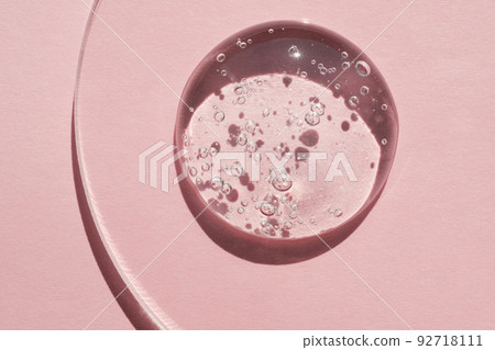 Gels cosmetic product drop in petri dish on pink background, hard shadows Gels cosmetic product drop in petri dish on pink background, hard shadows 92718111