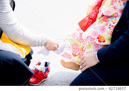 Making a child put on sandals Making a child put on sandals 92718657