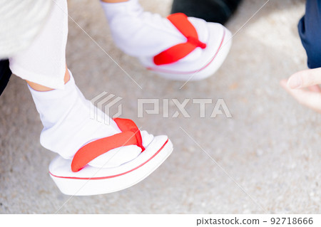 Making a child put on sandals 92718666