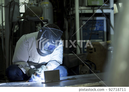 Welder image TIG welding Middle male worker who wears air-conditioning work clothes and welds 92718711