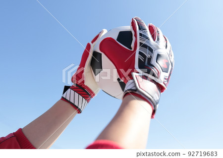 Goalkeeper man catching a soccer ball 92719683