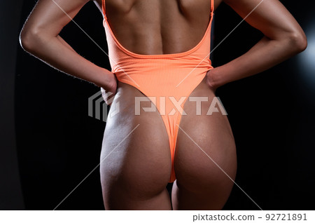 A faceless woman in an orange swimsuit demonstrates the result of an instant tan A faceless woman in an orange swimsuit demonstrates the result of an instant tan 92721891
