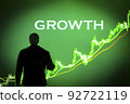 GROWTH word with the background of a businessman looking at the uptrending green graph GROWTH word with the background of a businessman looking at the uptrending green graph 92722119