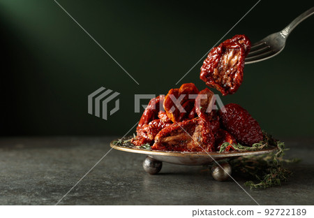 Sun-dried tomatoes with thyme in olive oil. 92722189