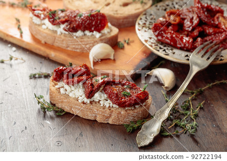 Bruschetta with ricotta, sun-dried tomatoes, and thyme. 92722194