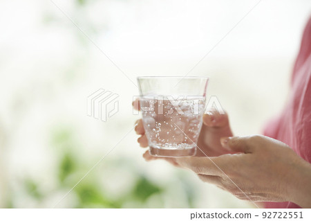 Middle woman's hand holding a glass of water Middle woman's hand holding a glass of water 92722551