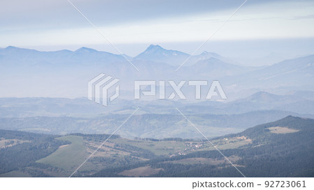 Autumn landscape with valley and big mountains disappearing in fog in the background, Europe Autumn landscape with valley and big mountains disappearing in fog in the background, Europe 92723061