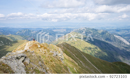 Alpine vista with mountain ranges and hiker going through them on a sunny day, Slovakia, Europe Alpine vista with mountain ranges and hiker going through them on a sunny day, Slovakia, Europe 92723103