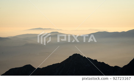 Alpine landscape with mountain ranges silhouettes during foggy sunset, Europe, Slovakia 92723167