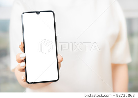Woman showing cell phone with blank screen. mockup Woman showing cell phone with blank screen. mockup 92723868