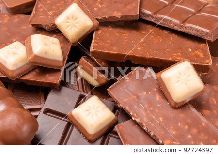 Top view of pieces of chocolate bar with chocolate chips on rustic wooden table background. Chocolate pieces on wooden table. copy space. top view Top view of pieces of chocolate bar with chocolate chips on rustic wooden table background. Chocolate pieces on wooden table. copy space. top view 92724397