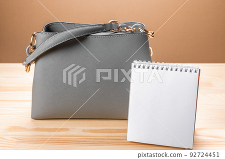 Womens leather handbag, white blank notepad. mockup image. space for text. Female workplace business background 92724451