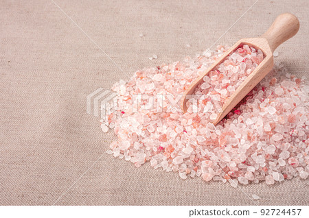 Pink himalayan salt. wooden scoop with pink himalayan salt on textile burlap background. Himalayan pink crystal salt 92724457