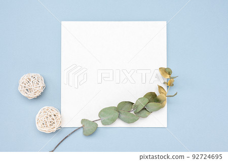 Mockup image. Square invitation card mock up with a gold eucalyptus branch. Top view of a white card mockup with branch of eucalyptus 92724695