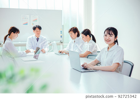 A nurse woman wearing a white coat and nurse clothes 92725342