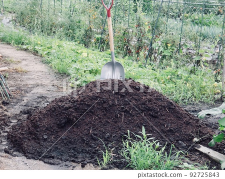 A shovel stuck in a pile of dirt A shovel stuck in a pile of dirt 92725843