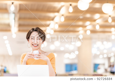 Middle-aged woman using a laptop in the working space Middle-aged woman using a laptop in the working space 92726884