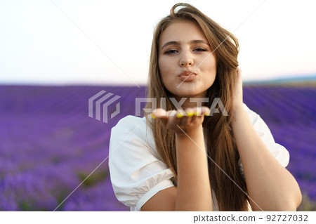 Portrait of a young attractive woman in a lavender field at sunset Portrait of a young attractive woman in a lavender field at sunset 92727032