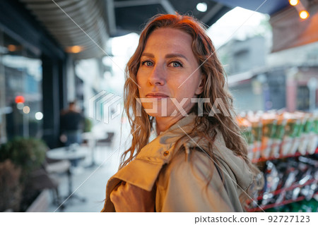 Portrait of a charming young woman posing for camera in the city Portrait of a charming young woman posing for camera in the city 92727123