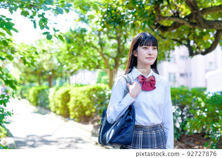 High school girls walking straight down the road under the beautiful fresh green, going to and from school, future course 92727876