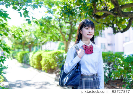 High school girls walking straight down the road under beautiful fresh green, going to and from school, future course, morning image color 92727877