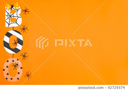 BOO lettering in Halloween style. Orange background and black spiders. Place for text. Copy space. Halloween concept. Flay lay. Top view. BOO lettering in Halloween style. Orange background and black spiders. Place for text. Copy space. Halloween concept. Flay lay. Top view. 92729374