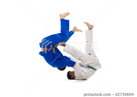Studio shot of two men, professional judo athletes training isolated over white background Studio shot of two men, professional judo athletes training isolated over white background 92730604