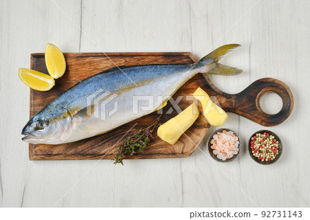 Overhead view of whole fresh chinook on wooden cutting board 92731143