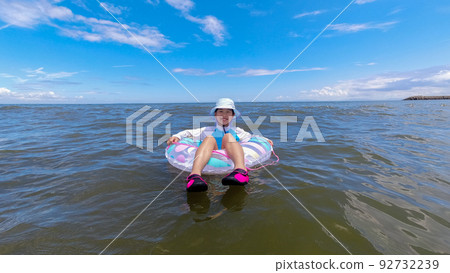 A cute elementary school girl playing at the beach in summer 92732239
