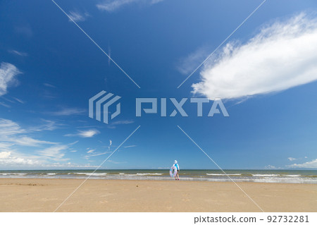 A cute elementary school girl playing at the beach in summer A cute elementary school girl playing at the beach in summer 92732281