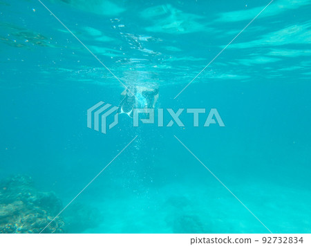 diver vanishing underwater in a distance 92732834