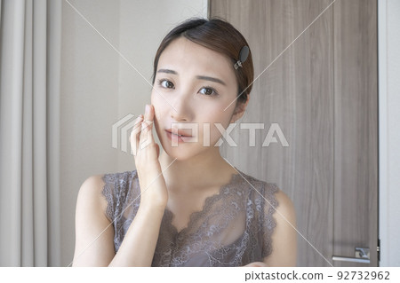 woman checking her skin woman checking her skin 92732962