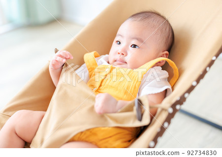 baby sitting on bouncer 92734830