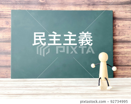 黑板上寫著“民主”一詞和一個木頭 92734995