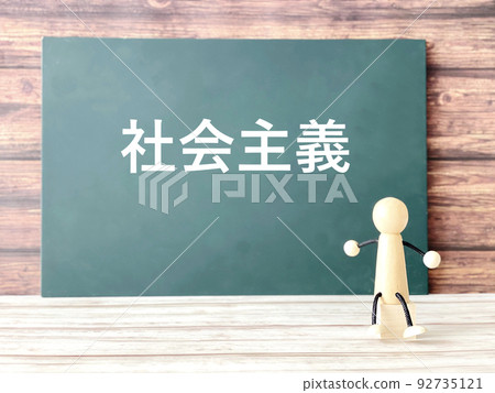 Chalkboard with socialism lettering and wooden puppets Chalkboard with socialism lettering and wooden puppets 92735121
